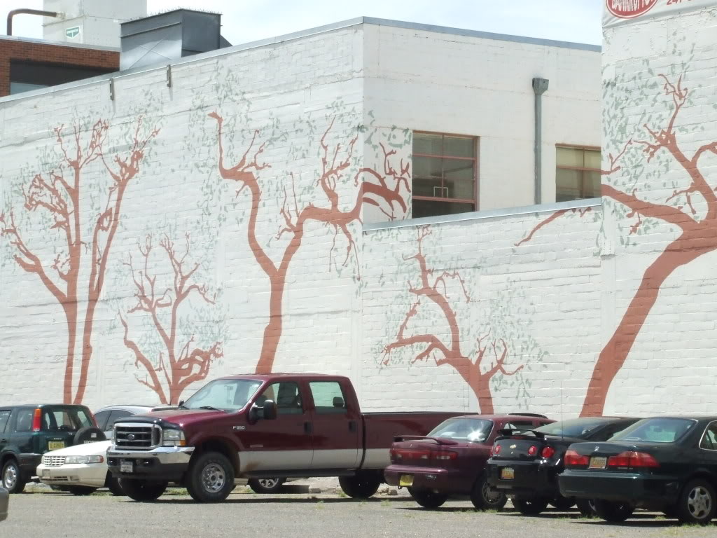trees painted up on the windowless side of a two-story building