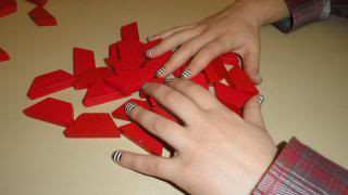 3-D puzzle pieces, red, and hands.