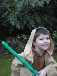 Adam in a Jedi robe with lightsabre