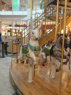 white rabbit on a carousel, in a mall